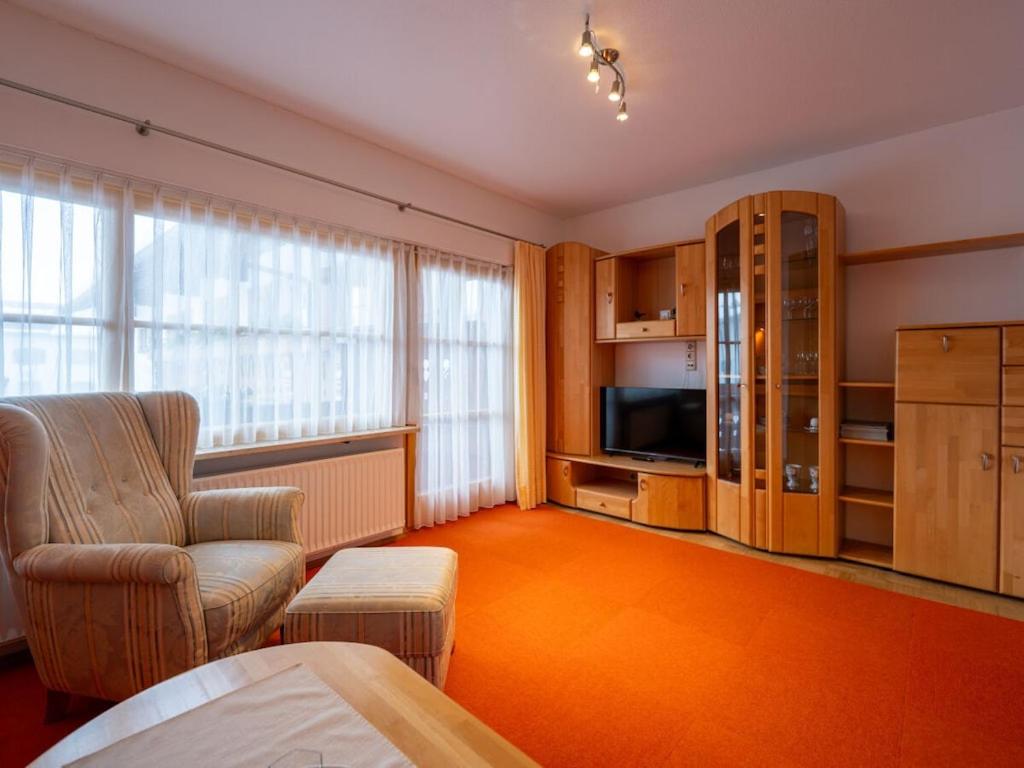 een woonkamer met een bank, een stoel en een televisie bij House Alpenlicht in Reit im Winkl