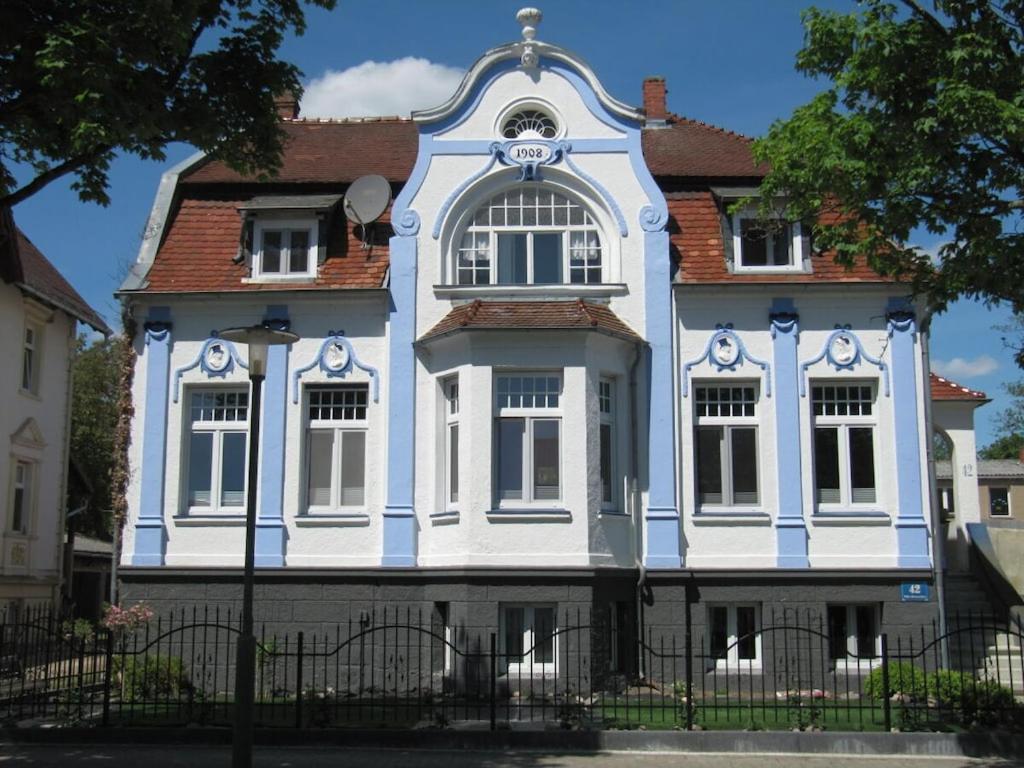 ein blau-weißes Haus mit einem Zaun davor in der Unterkunft Villa Romantica Lenzen in Körbitz