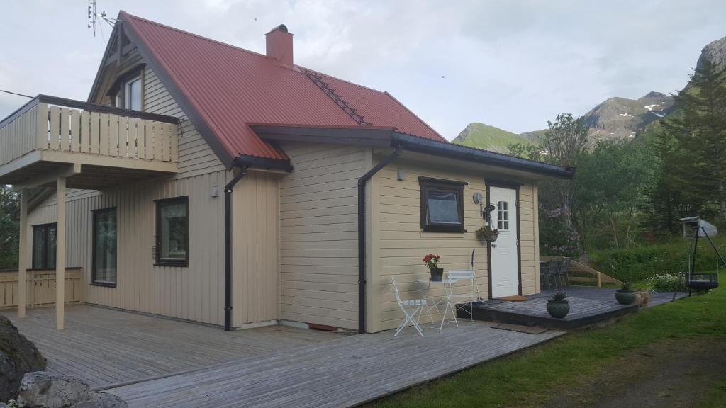 een huis met een terras en een huis met een rood dak bij Holiday Home Lofoten in Lyngværet