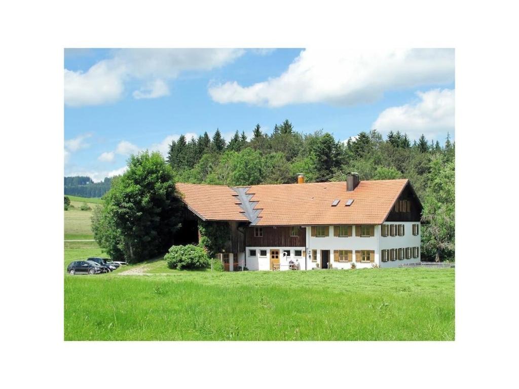 una grande casa in un campo con una macchina davanti di Holiday home with 2 bedrooms a Buchenberg