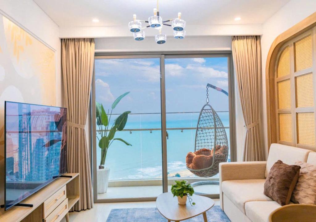 The Sóng OCEAN VIEW Apartment Vung Tau - Căn Hộ Du Lịch Bãi Sau Vũng Tàu - Linh House في فنغ تاو: غرفة معيشة مع نافذة كبيرة مطلة على المحيط