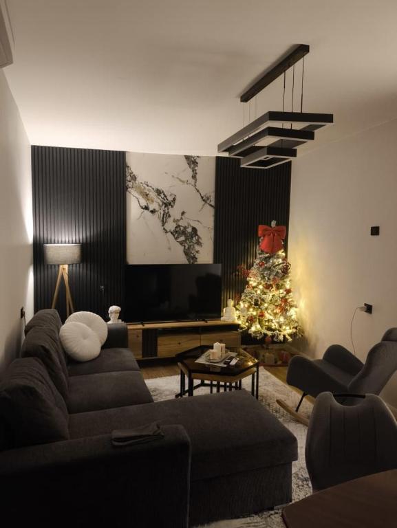 a living room with a christmas tree and a couch at Pri Home in Pristina