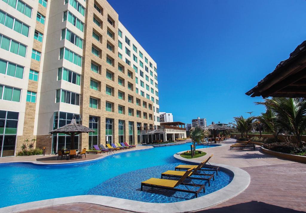 uma piscina em frente a um grande edifício em Gran Mareiro Hotel em Fortaleza
