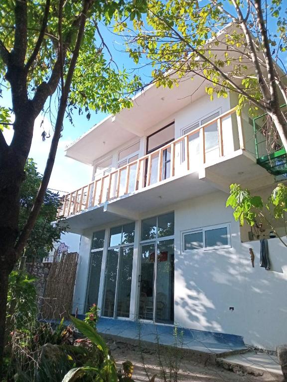 a house with a balcony on top of it at Hostel Casa escondida in Santa Cruz La Laguna