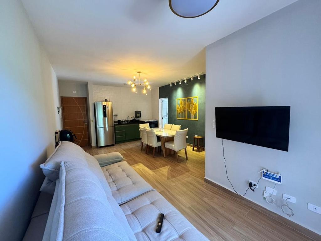 un salon avec un canapé et une salle à manger dans l'établissement Apartamentos das Toninhas, à Ubatuba