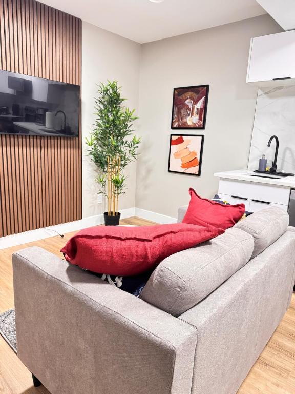 a couch with red pillows on it in a living room at NorthEdge Suites in Edmonton