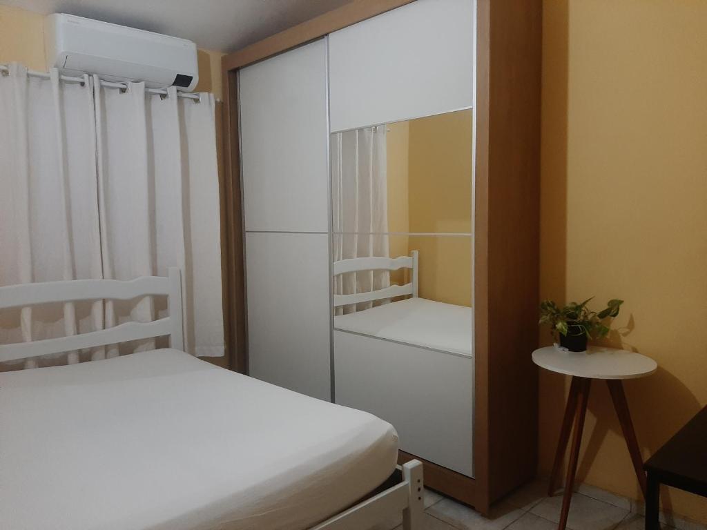 1 Schlafzimmer mit 2 Betten und einem Glasschrank in der Unterkunft Ellen2000 in Fortaleza