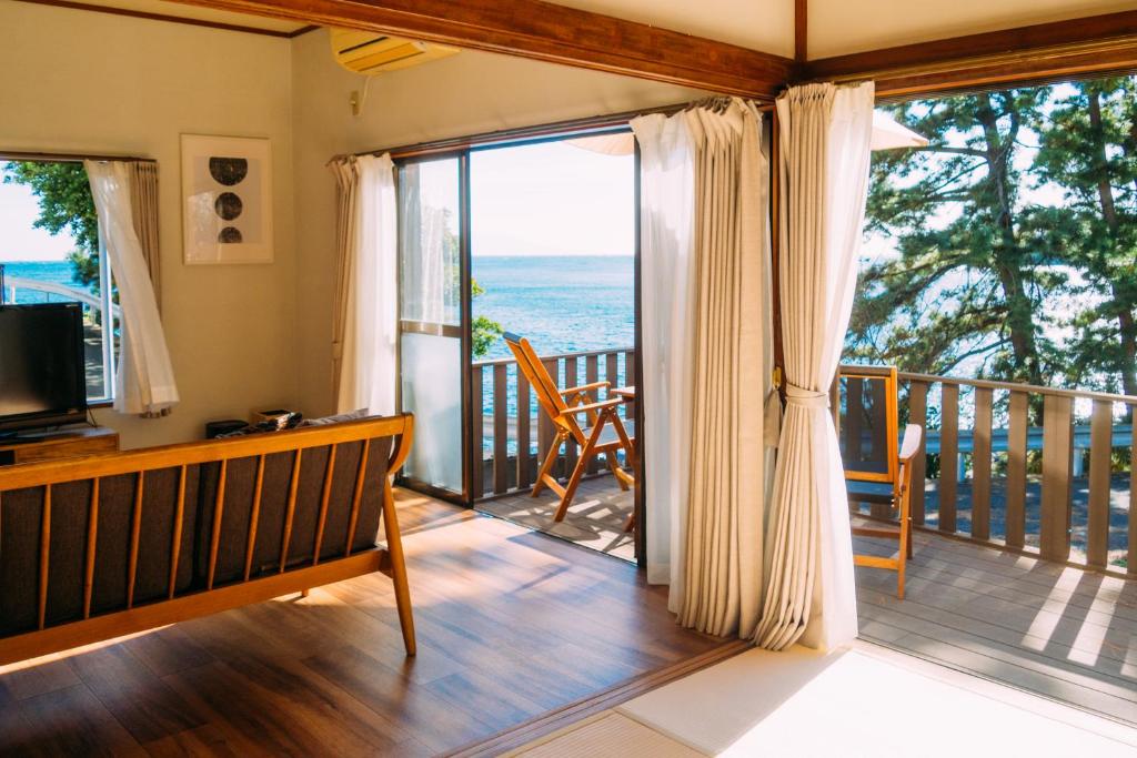 a room with a balcony with a view of the ocean at ふとの情景 Futo Nostalgia in Ito