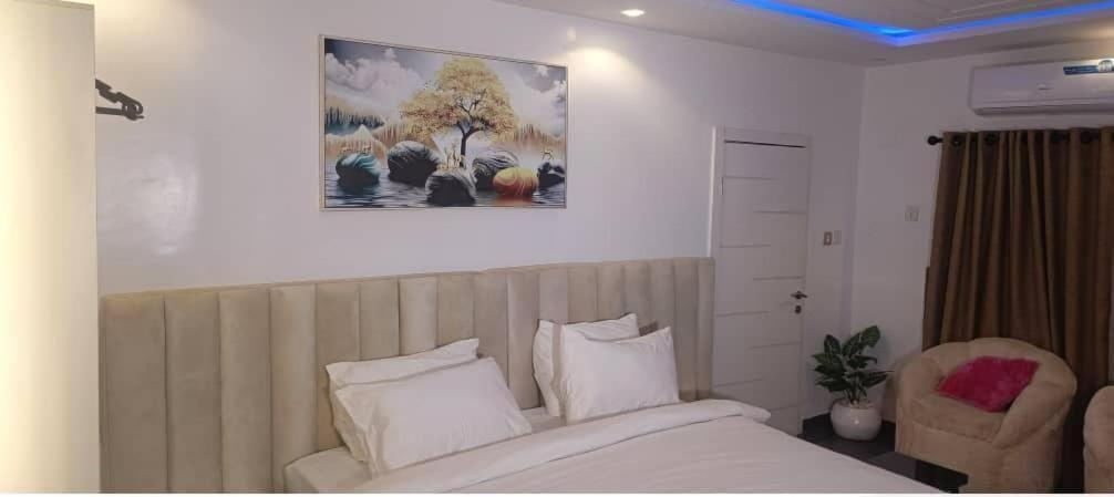 a bedroom with a bed and a picture on the wall at Micangelo shortlet apartment in Idimu