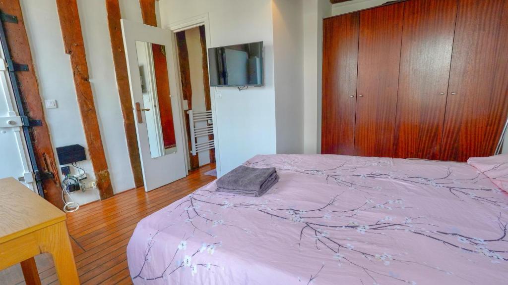 1 dormitorio con cama morada y armario de madera en 12 Lovely Studio Steps from Boulevard Saint Germain, en París