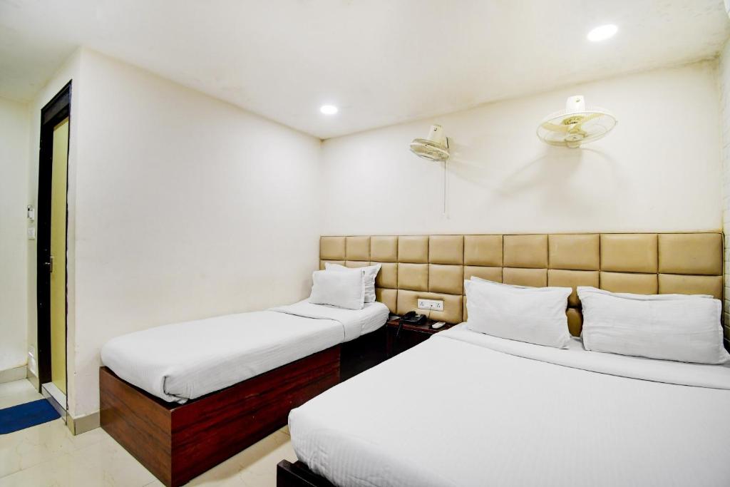 加尔各答Hotel O Kyd Guest House的有两张床和一扇窗户的卧室