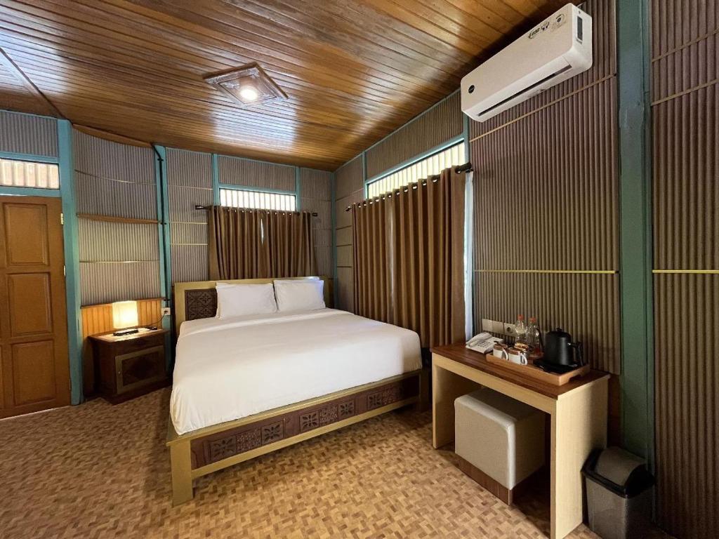 una camera con letto, comodino e letto sidx sidx sidx. di Onsen Resort Kaliurang a Mantaak