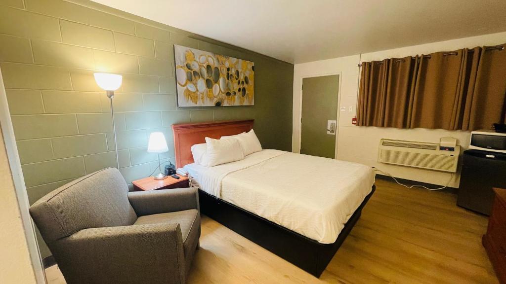 una habitación de hotel con una cama y una silla en Nelson Hotel, en Swan River