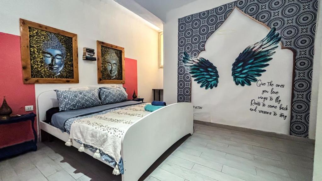 a bedroom with a bed and a wall with pictures at Gumantu Stay in Praia a Mare