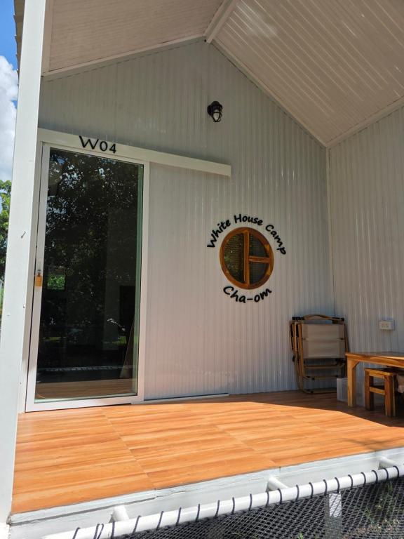 un portico coperto con pavimento in legno e canestro da basket di ไวท์ เฮ้าท์ แคมป์ ชะอม a Ban Bung Mai