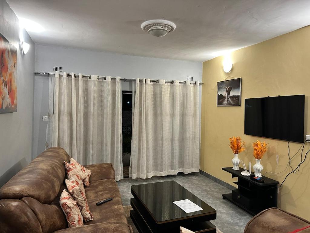 ein Wohnzimmer mit Couch und Flachbildfernseher in der Unterkunft Hatfield staylax Manor 2 in Harare