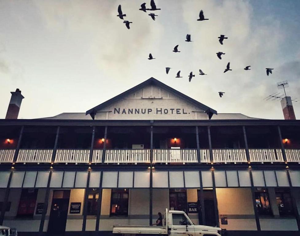 una bandada de pájaros volando sobre un edificio en Nannup Hotel Motel, en Nannup