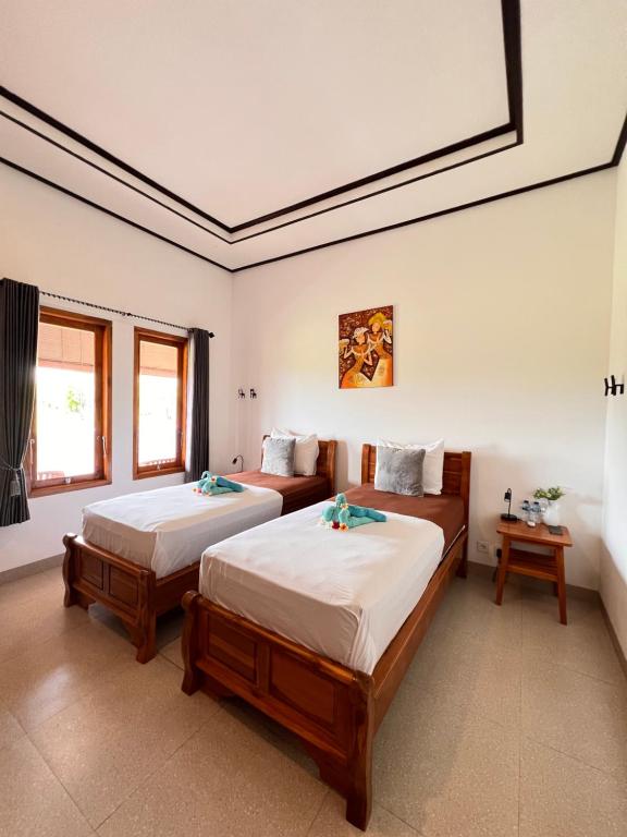 una camera da letto con due letti in una stanza di Villa Saudara a Data