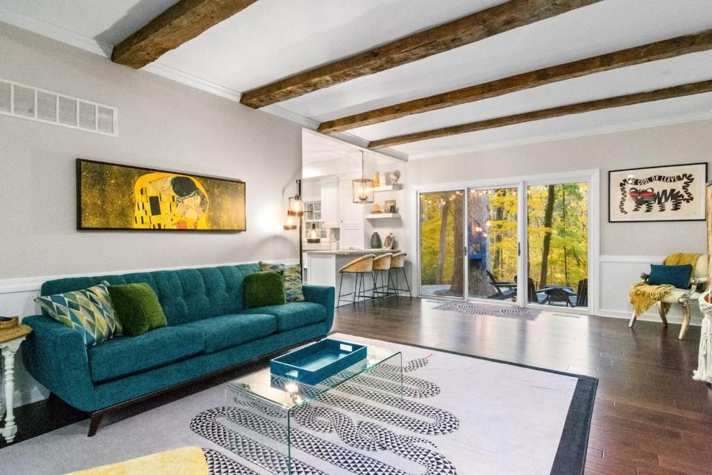 un soggiorno con un divano blu e un tavolo di The Hideaway 4200 Luxury 4BR Home with Theater Game Room Fire Pit and Gym a Evansville