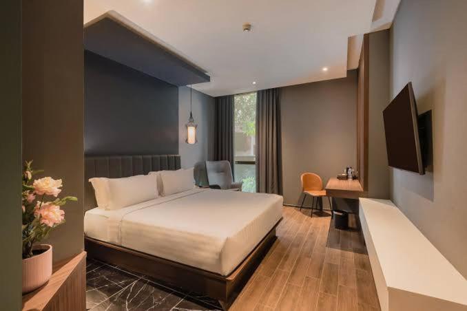 a bedroom with a bed and a desk and a television at RedDoorz Homestay VIP in Jakarta