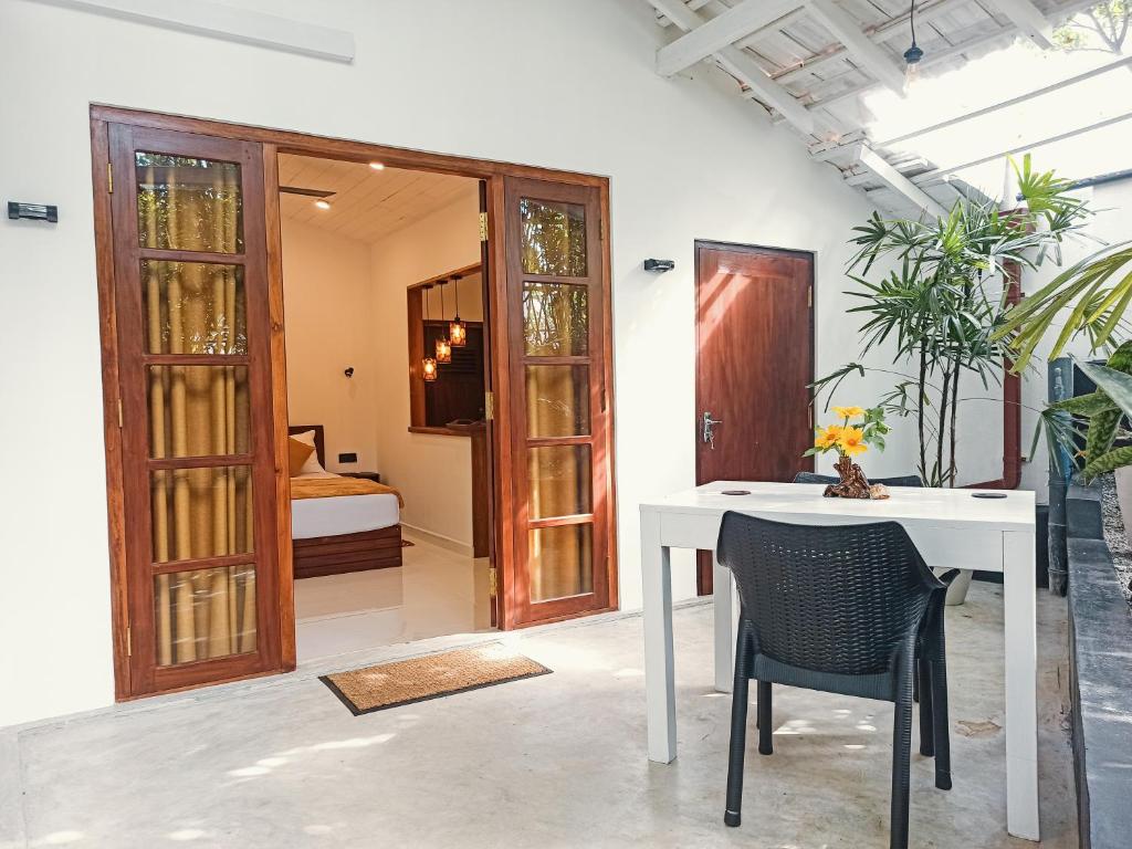 a white table and chair in a room with a bedroom at Mellow Yellow Ahangama in Ahangama