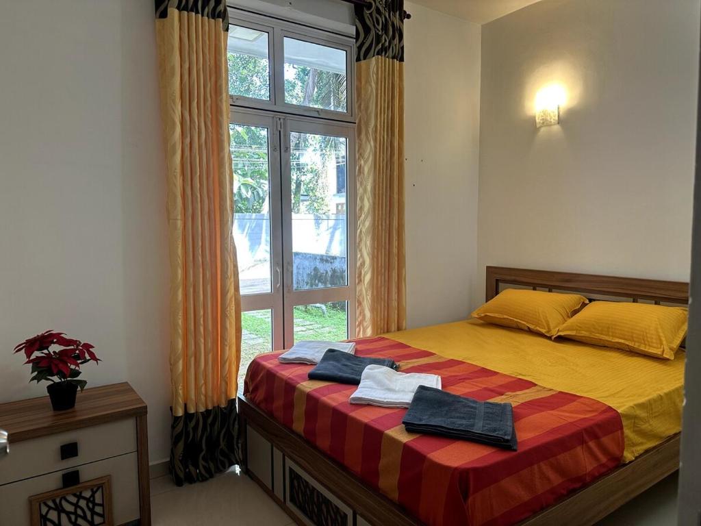 a bedroom with a bed and a large window at Prime Residencies Panadura - Convenient Apartment in Panadura