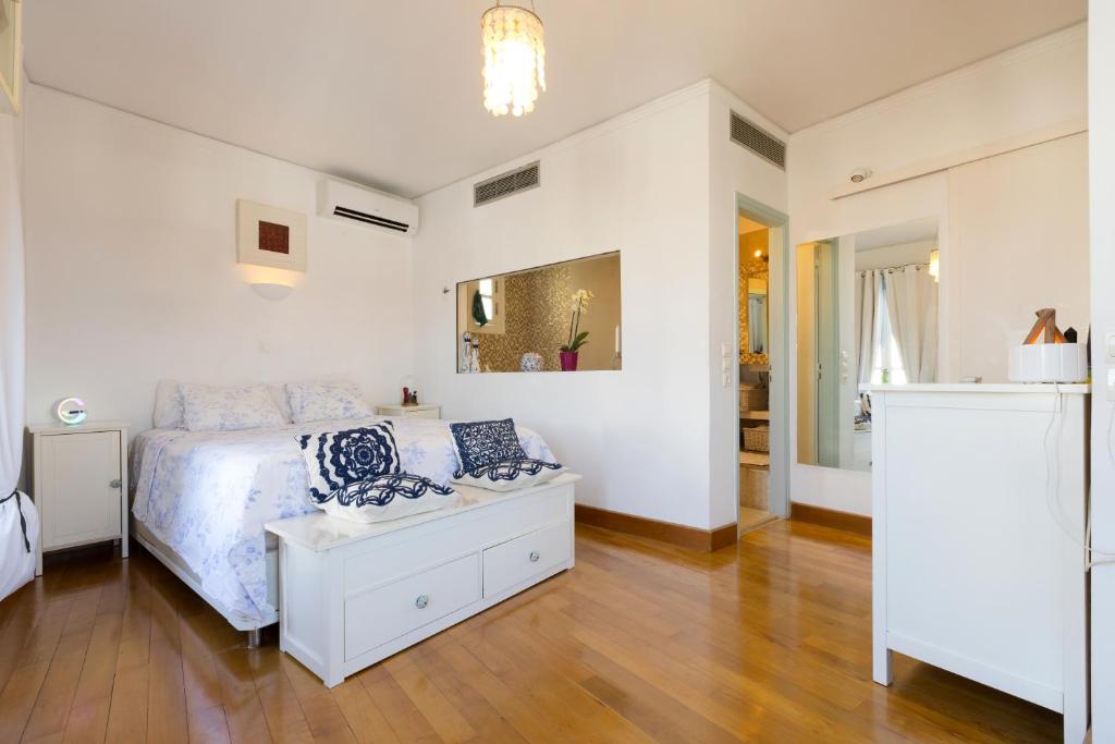 Villa Giasemi في سبيتسيس: غرفة نوم بيضاء مع سرير وطاولة