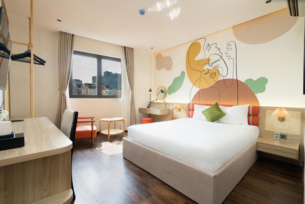 a bedroom with a large bed with a painting on the wall at Nicecy Hotel - Lê Lai Street in Ho Chi Minh City