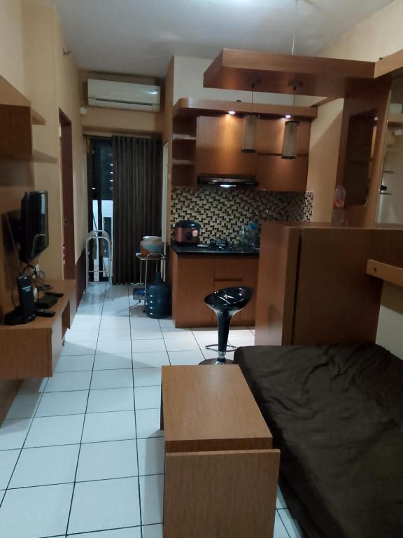 a room with a kitchen and a living room at Aparta Homestay in Pekayon Satu
