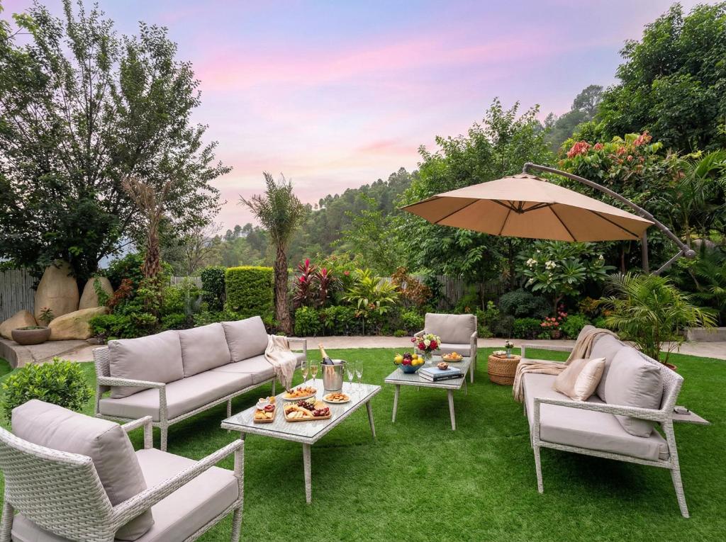a patio with a table and chairs and an umbrella at Tatva Hills Mountain Resort in Bhikia Sain