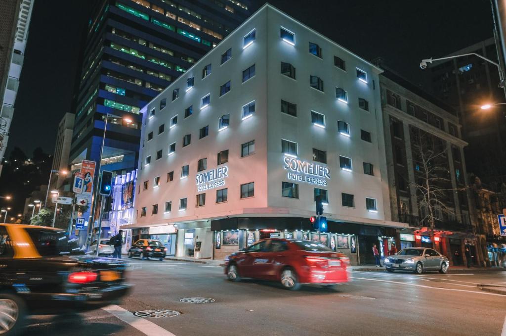 un edificio en una concurrida calle de la ciudad por la noche en Hotel Sommelier Agustinas, en Santiago