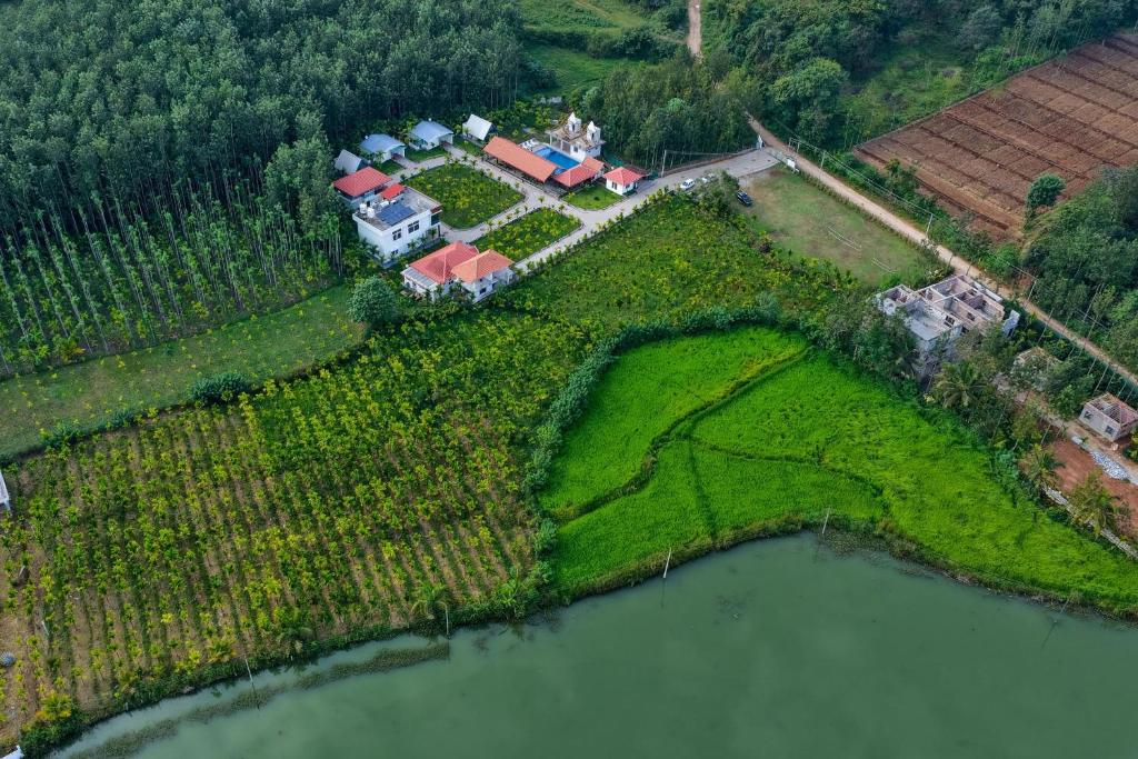 VastāraRG The Grand Haven Resort的享有湖畔农场房屋的空中景色