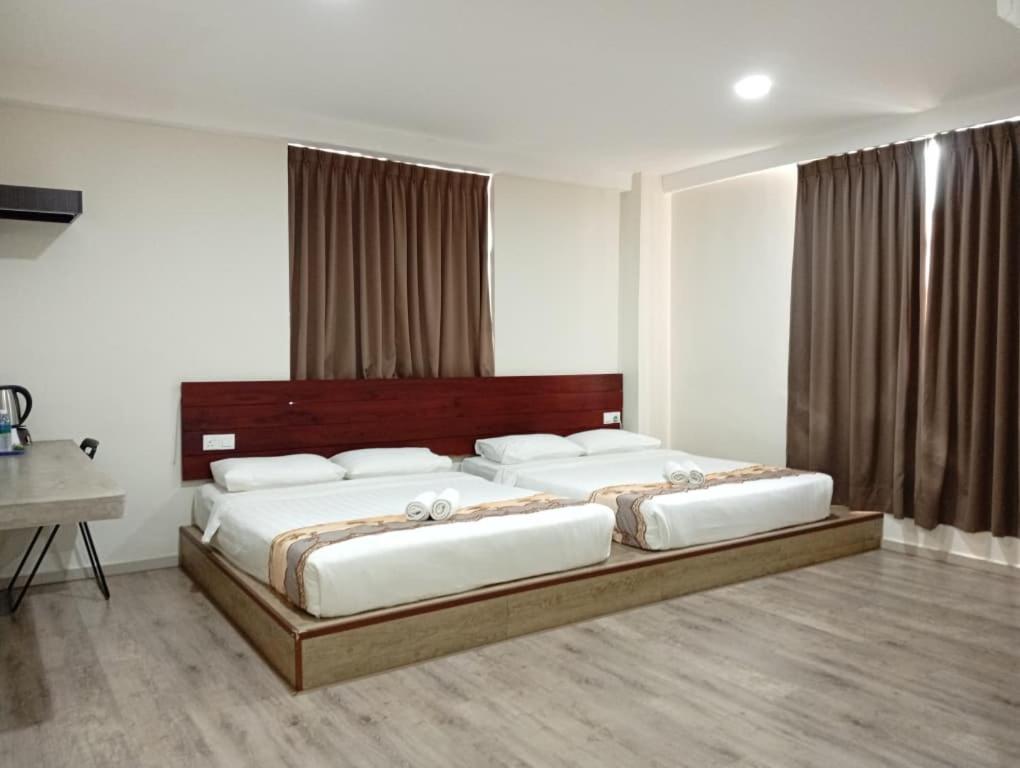 una camera da letto con un letto grande con cuscini bianchi di Mass Boutique Hotel a Mentekab