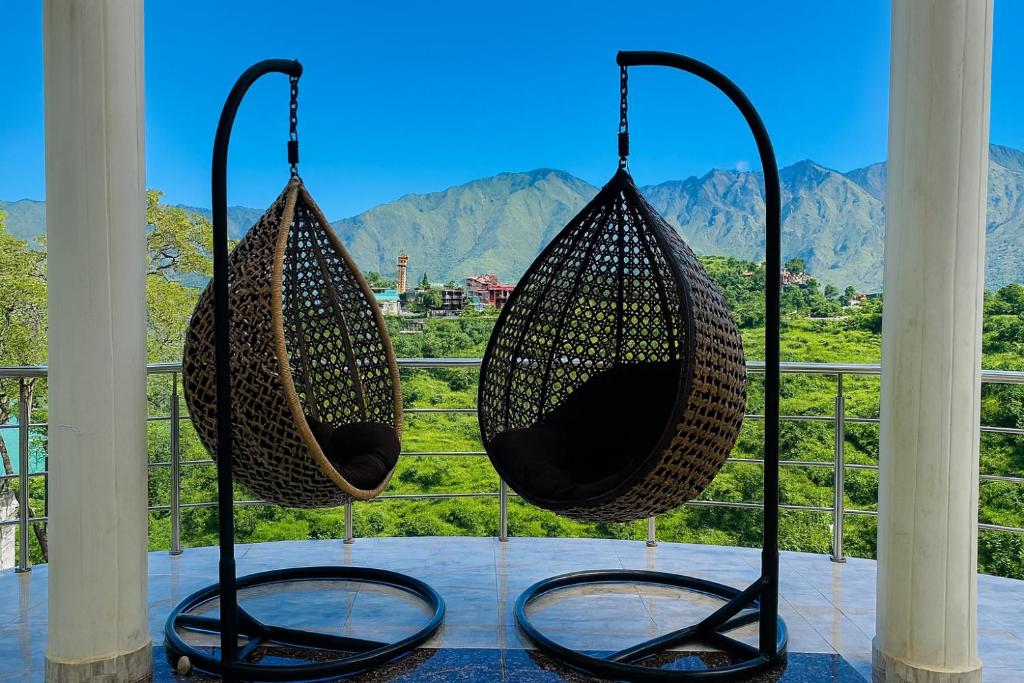 two hanging baskets on a porch with a view of mountains at Sitara Hotel & Resort in the lap of nature, Mussoorie in Mussoorie