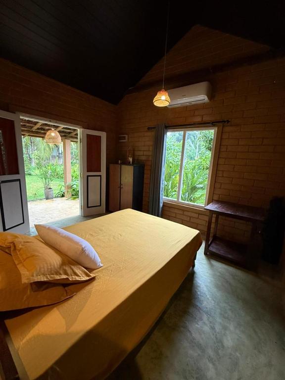 a bedroom with a large bed and a window at Eco Bricks in Ahangama