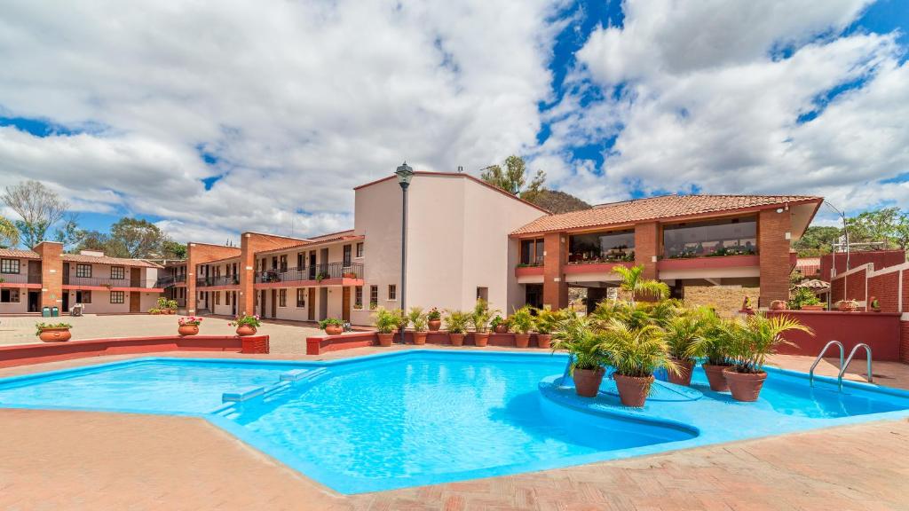 a swimming pool in front of a building at Villas del Sol Hotel & Bungalows in Oaxaca City