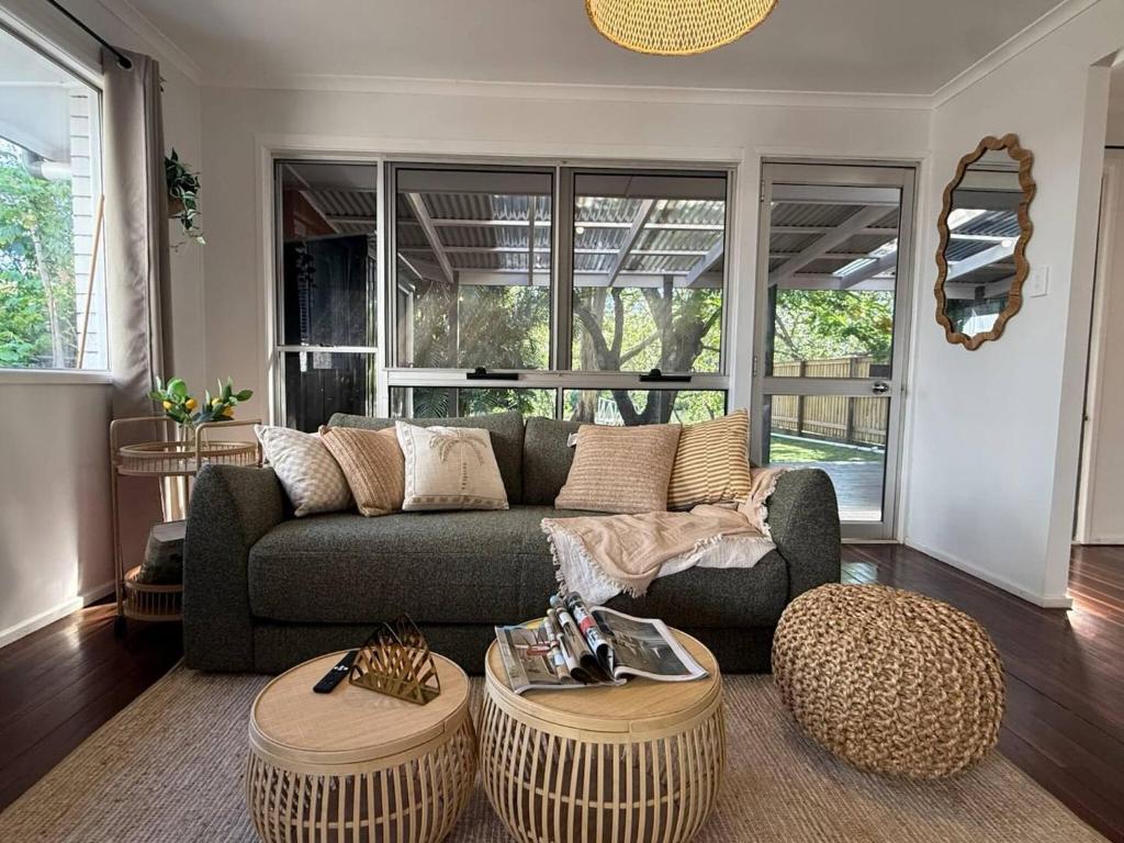 Una sala de estar con un sofá y dos mesas. en Chic Urban Escape in Norman Park, en Brisbane