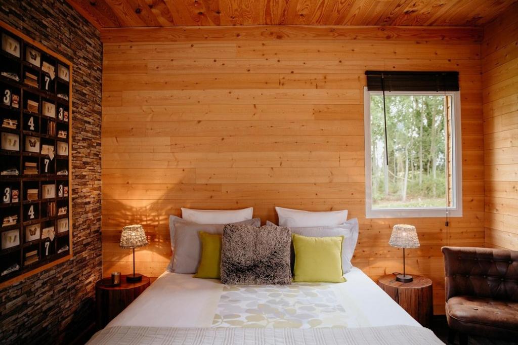 une chambre avec un lit dans un mur en bois dans l'établissement Le Clos De La Roche, à Goven
