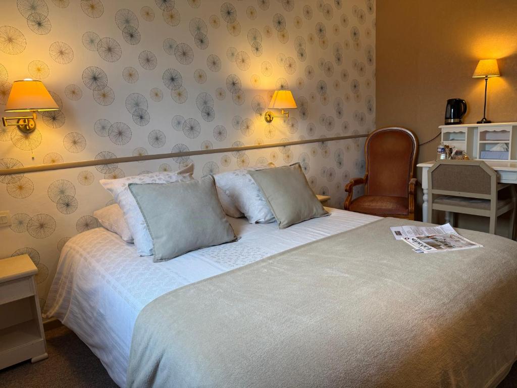 a bedroom with a large bed and a chair at Les 3 rois by YY in Villers-Bocage