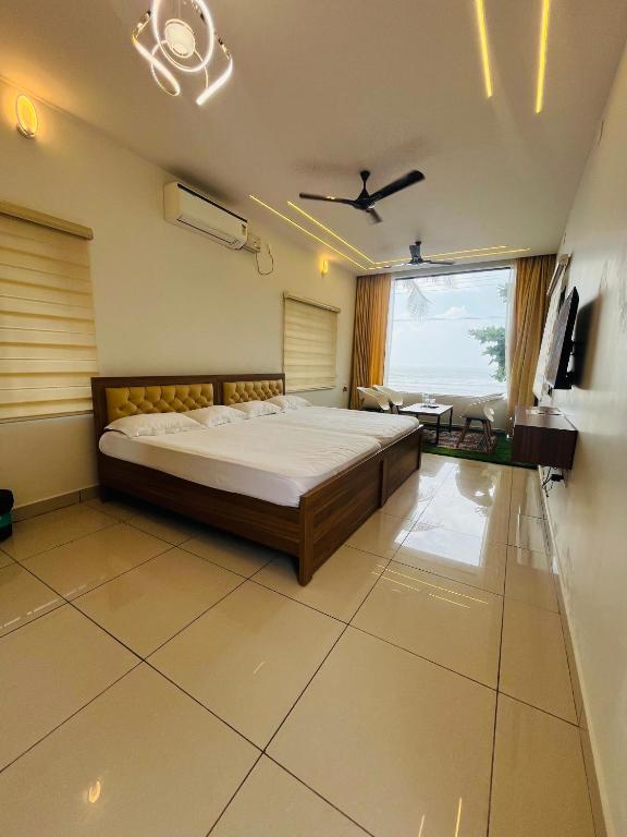 MalpeBeach Escape - Malpe Beach的一间卧室，配有一张大床和一扇大窗户。