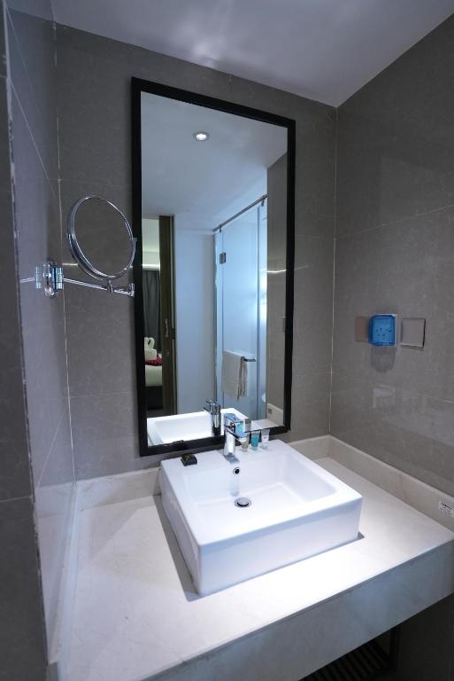 bagno con lavandino bianco e grande specchio di The Airport Hotel Muscat a Mascate
