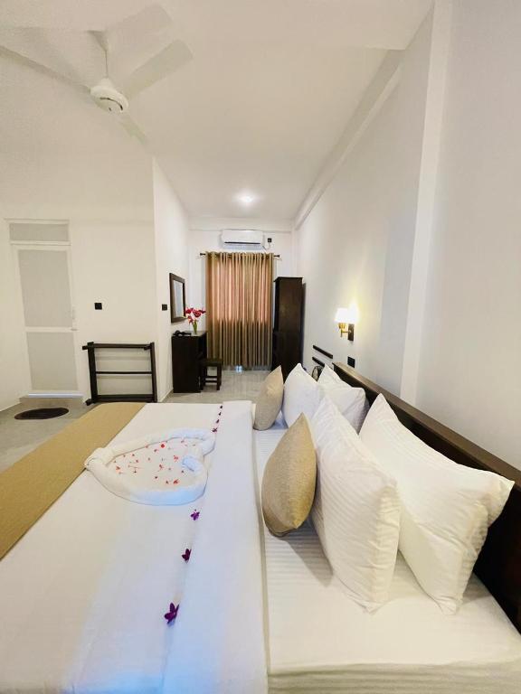 a large white bed with white pillows in a room at SKY Heaven in Weligama
