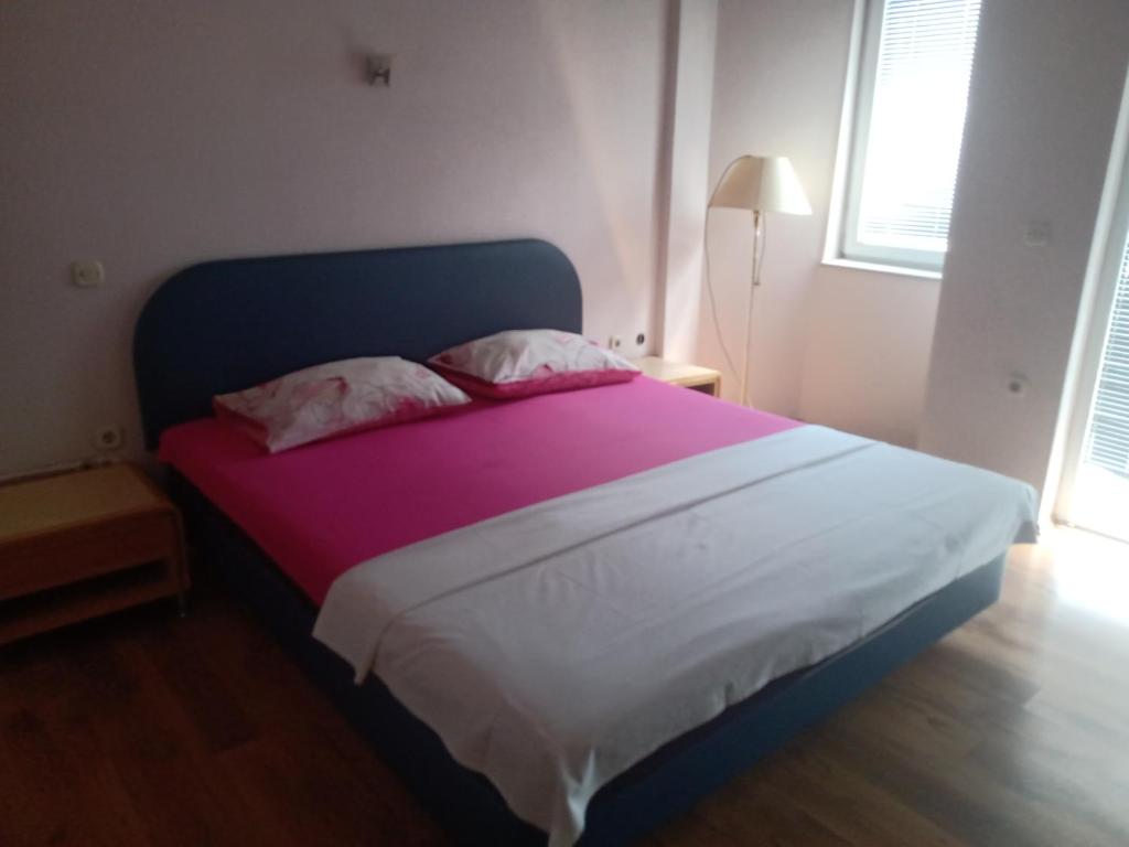 ein Schlafzimmer mit einem großen Bett mit einer lila und weißen Decke in der Unterkunft carshija in Struga