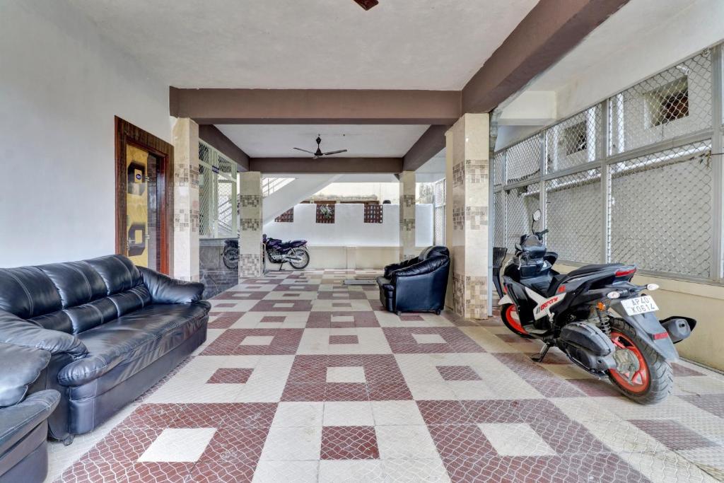 a motorcycle parked in a living room with a couch at Hotel O SESHADRI HOMESTAY in Tirupati