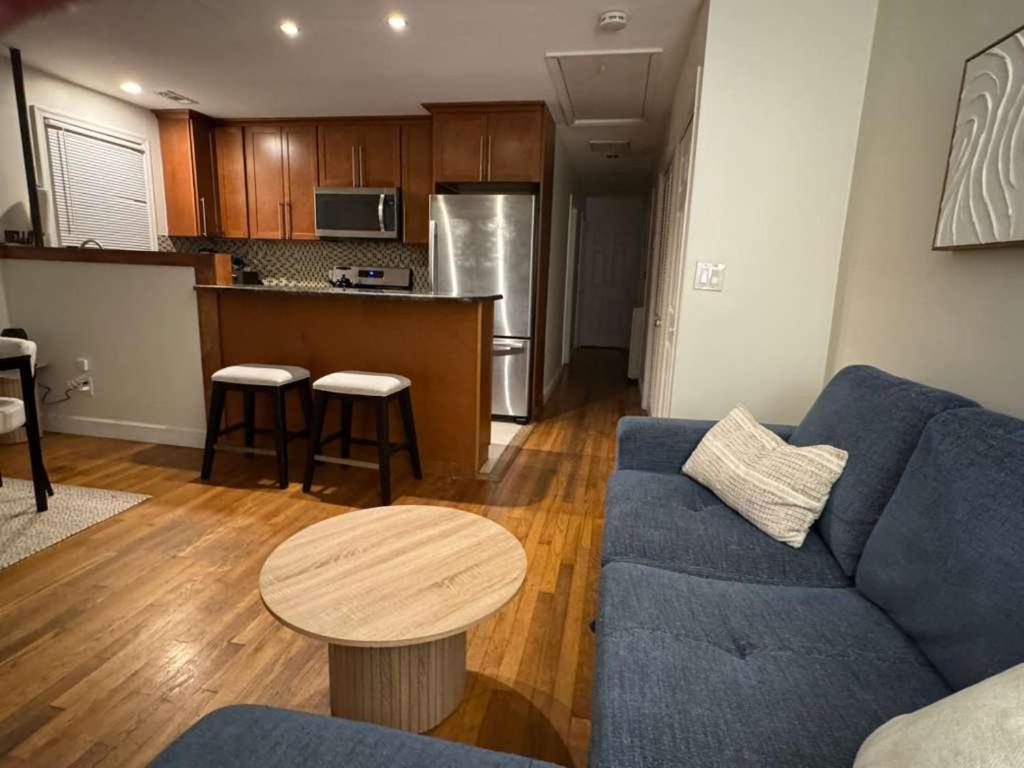 a living room with a blue couch and a table at Bright 2BR and1BA Home Near Old Town, Metro, Airport and Potomac Yard in Alexandria