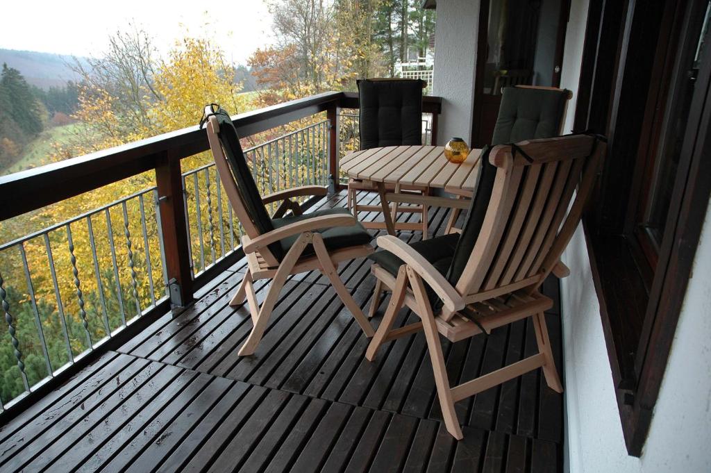 a porch with two chairs and a table on a balcony at Ferienhaus Schanze19 in Schmallenberg