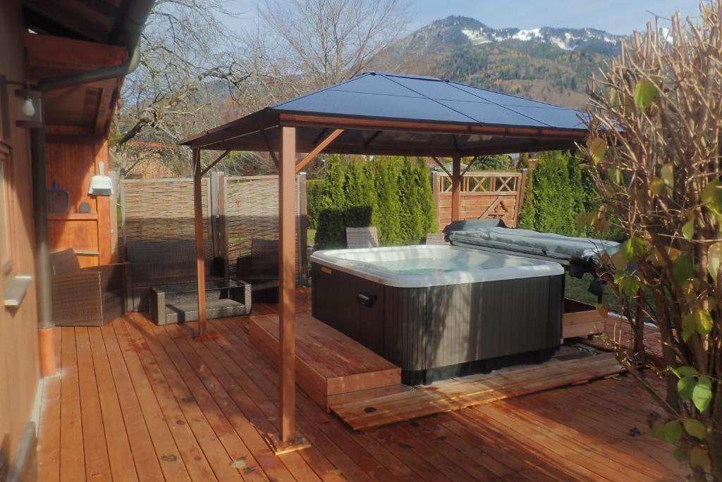 a hot tub under a gazebo on a deck at Chiemgauferienwohnungen - Wanderlust und Alpenrose in Unterwössen