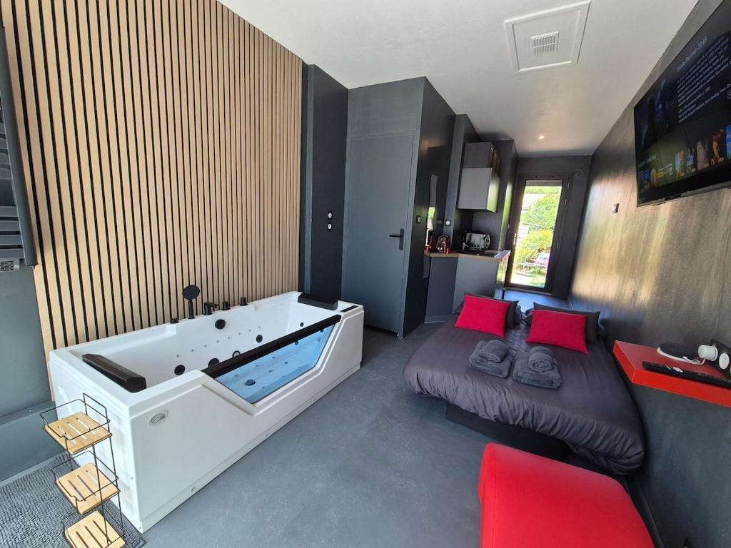 Studio Balnéo Bord de mer Fouras - 800m de la plage في فورا: حوض استحمام كبير في غرفة مع أريكة