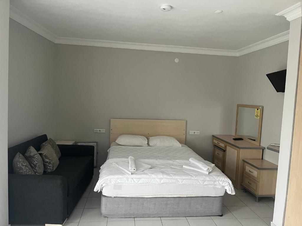 a bedroom with a bed and a couch in it at Eldorado Hotel in Kumluca