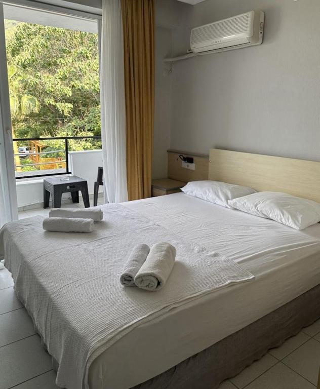 a bedroom with a large bed with towels on it at Eldorado Hotel in Kumluca